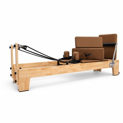 REFORMIA Oak Wood Pilates Reformer with Cinnamon Clay upholstery and solid oak frame, three-quarter studio view